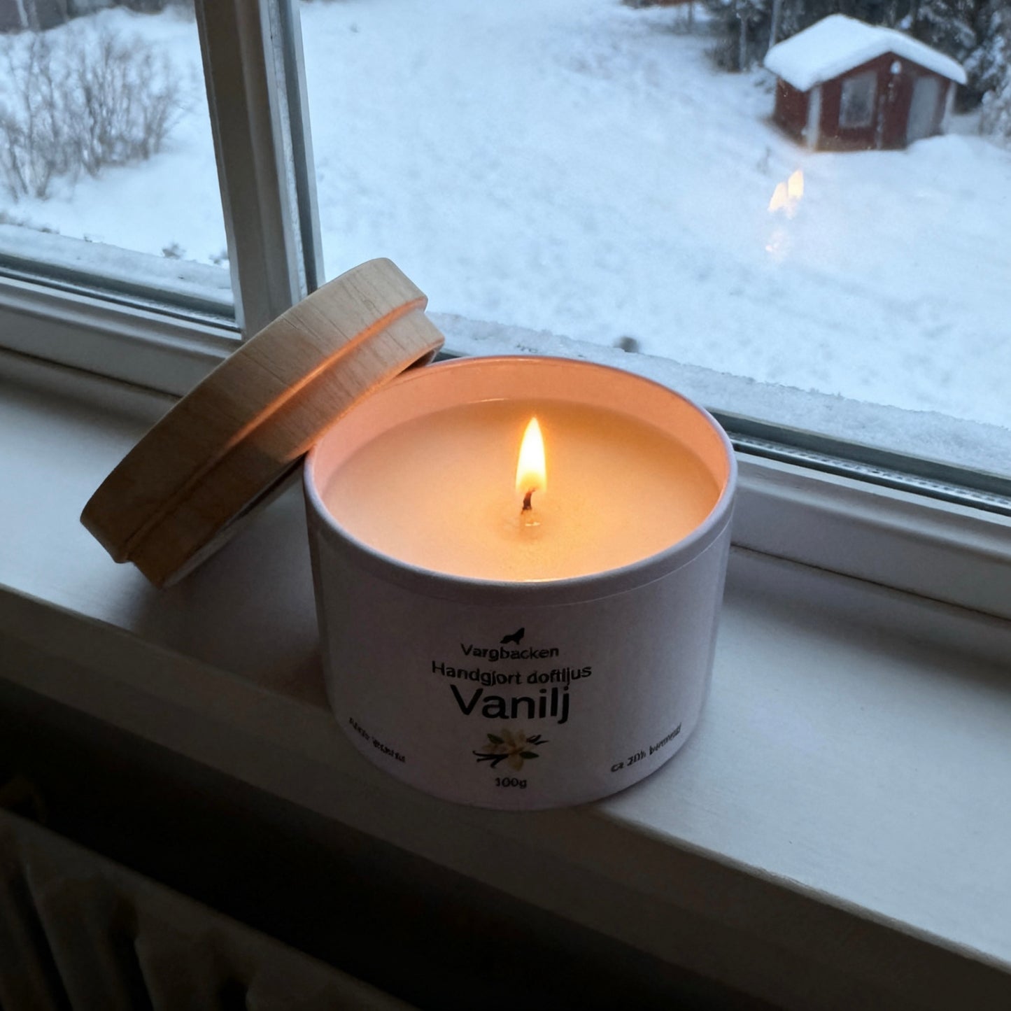 Någon tänder Vargbacken Vanilj ljus i mysig miljö Sojavax vegansk present